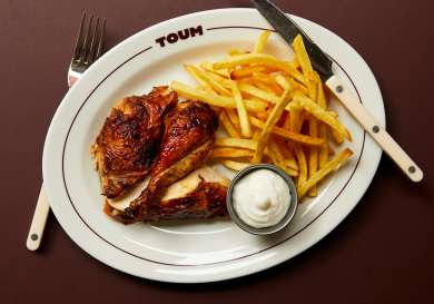 Photo of plate of chicken and chips at toum restaurant .