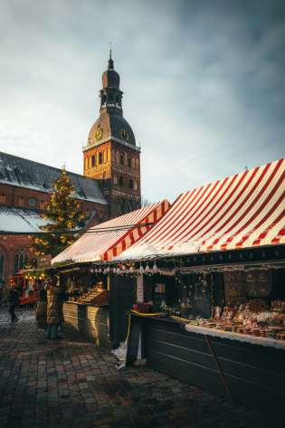 Photo of christmas market with striped awnings .
