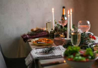 Christmas meal laid on table with white candles.