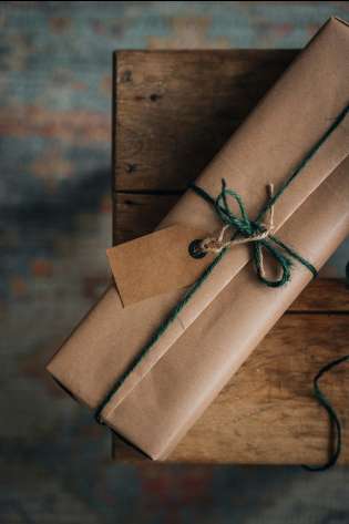 Christmas present wrapped in brown paper and with green string.