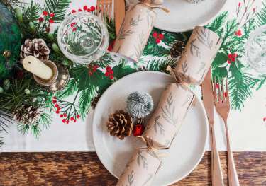 Christmas table setting with pinecones and crackers.