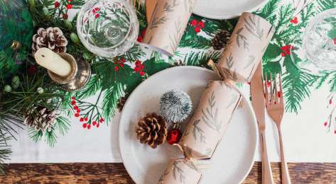 Christmas table setting with pinecones and crackers.