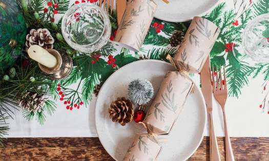 Christmas table setting with pinecones and crackers.