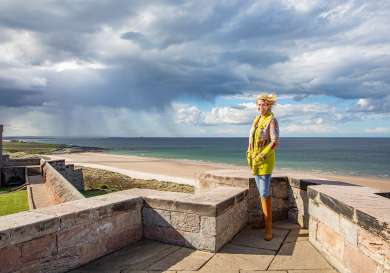 Photo of claire watson armstrong posing at bamburgh castle .