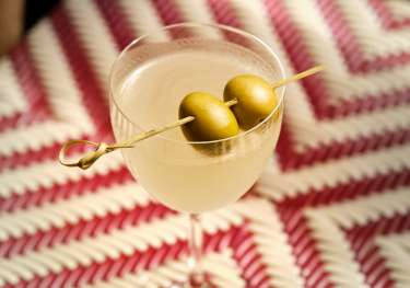 Cocktail with two large olives resting on the top.