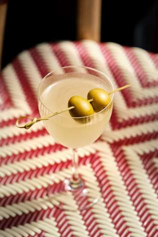 Cocktail with two large olives resting on the top.