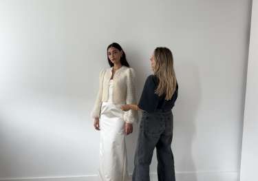 Person styling a model in bridal wear .
