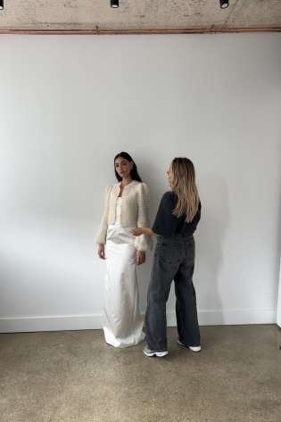 Person styling a model in bridal wear .