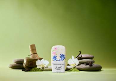 Fussy deodorant with matcha and vanilla on green background.