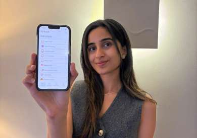 Woman holding phone showing app .