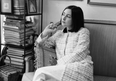 Black and white portrait of woman sitting on sofa.