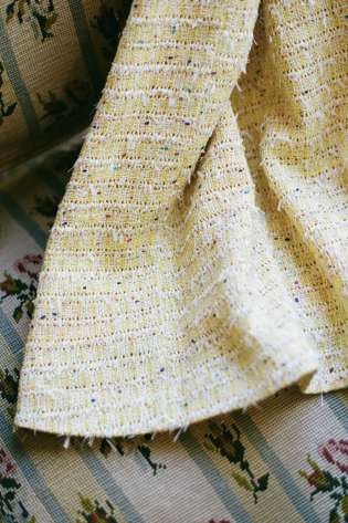 Hem of yellow tweed dress.