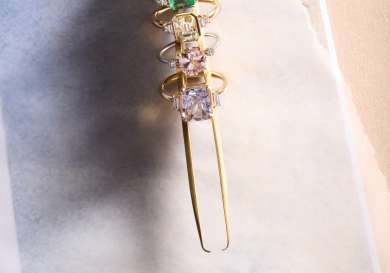 Five multi-coloured rings on golden tweezer.