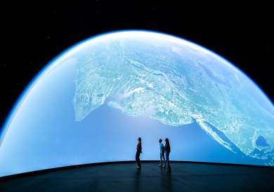 Photo of three people looking at installation inside dome.