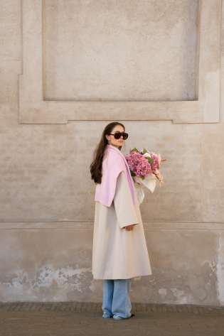 Woman posing with a bouquet of pink flowers.
