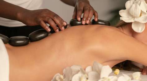 Woman getting stone massage.