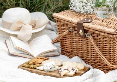 Picnic basket with cheese, olives and biscuits.
