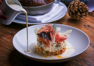 Christmas dish with creamy sauce served on wooden table.