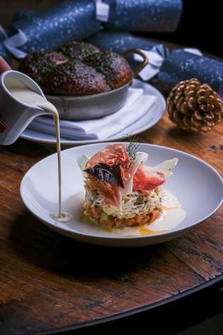Christmas dish with creamy sauce served on wooden table.