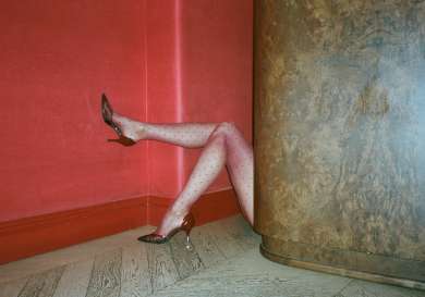 Model posing in polka dot tights and red glossy heels.