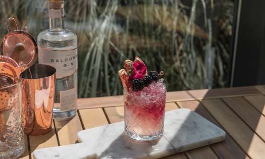 Blackberry cocktail on marble serving board.