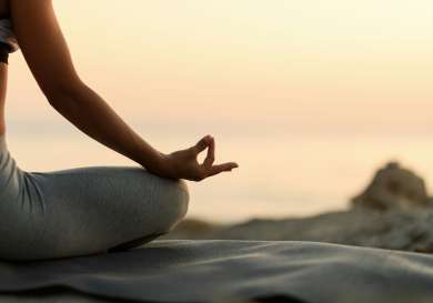 Woman doing yoga seated pose at sunset.