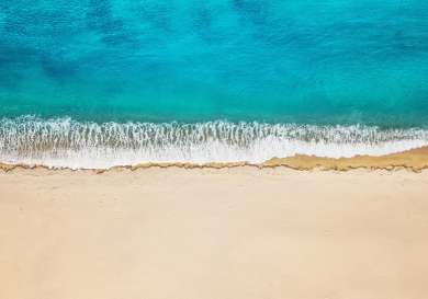 Aerial view of beach with tuquoise sea .