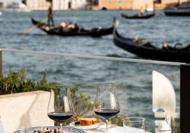 Table set for two beside venice waterway.