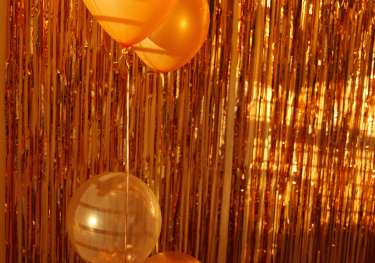 Gold balloons with gold streamer background.