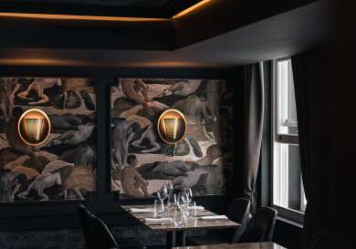 Restaurant at hotel gotham with illustrated walls and warm lighting.