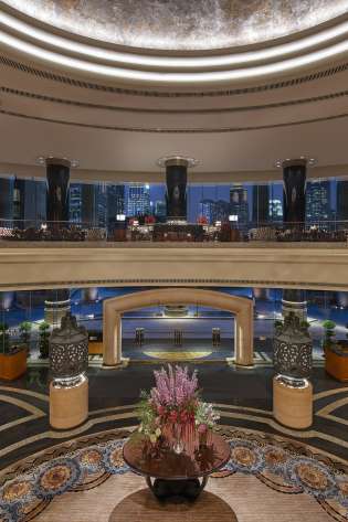 Hotel atrium with vase of flowers in the centre.