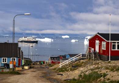 Town in greenland with cruise ship in the background.