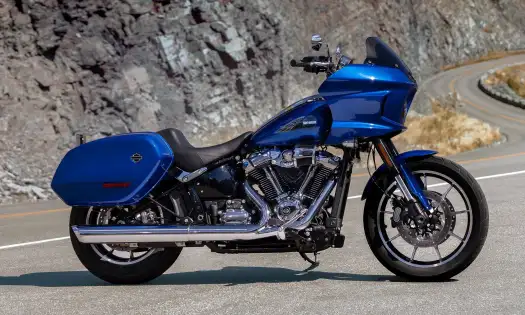 Harley davidson blue bike parked on road .