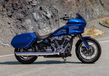 Harley davidson blue bike parked on road .