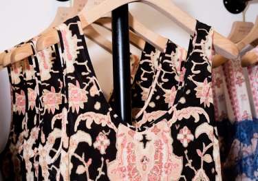 Patterned dress hanging on clothes rack in shop .