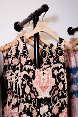 Patterned dress hanging on clothes rack in shop .