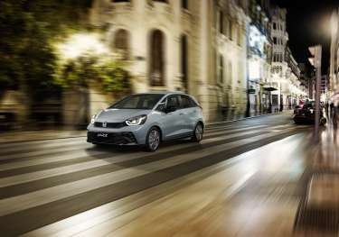 Honda jazz car driving along road at night.