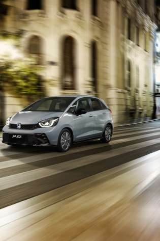 Honda jazz car driving along road at night.
