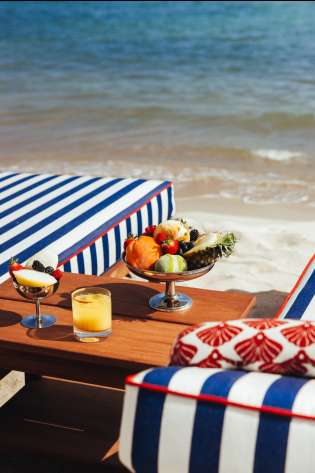 Silver bowl of fruit by sun loungers.