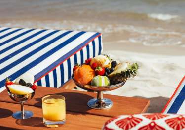 Silver bowl of fruit by sun loungers.