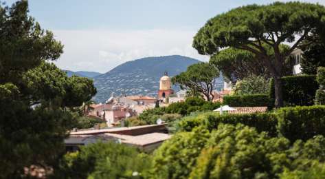 View across french town with trees in the foreground.