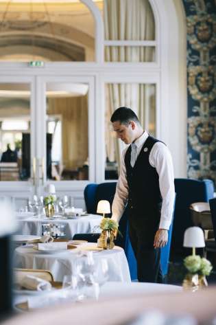 Waiter setting table in hotel restaurant .