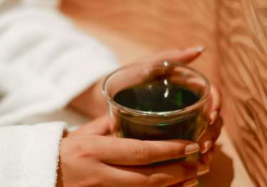 Woman holding cup of green tea.