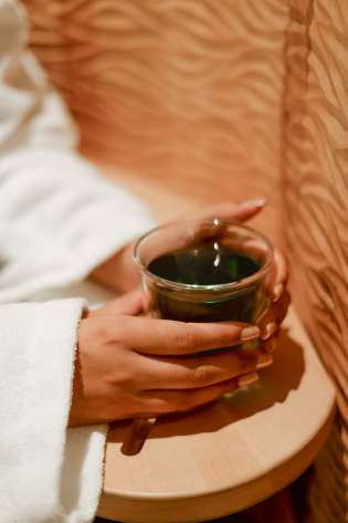 Woman holding cup of green tea.
