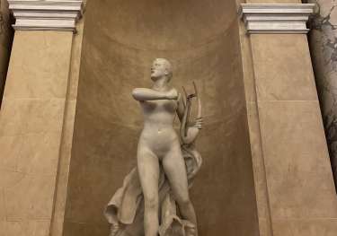 Sculpture of person inside domed arch.