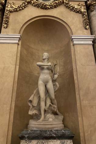 Sculpture of person inside domed arch.