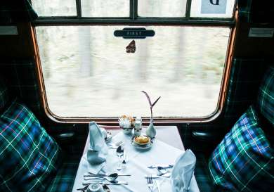 Interior of train with tartan seating and cushions .