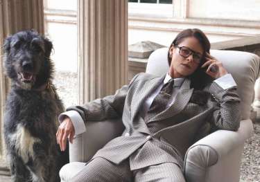 Portrait of jade holland cooper sat in chair next to dog.