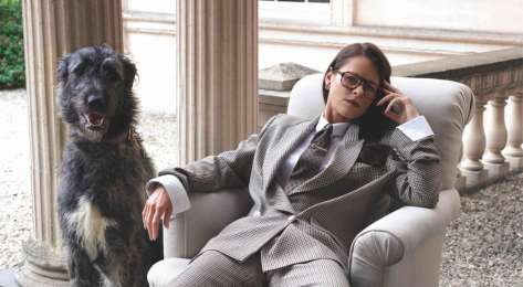 Portrait of jade holland cooper sat in chair next to dog.