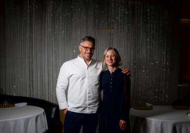 Two people posing for portrait in resraurant.